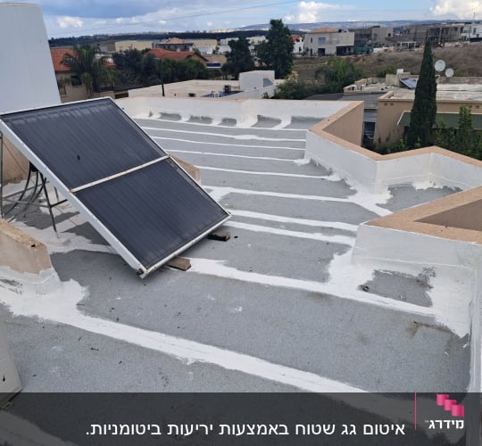 גג אטום עם שכבת איטום לבנה סביב קולטי שמש